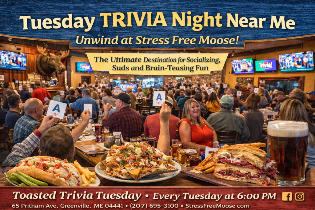Crowd enjoying Tuesday trivia night at Stress Free Moose pub in Greenville, Maine, holding trivia answer cards with pub food, craft beer, and a lively Moosehead Lake atmosphere.